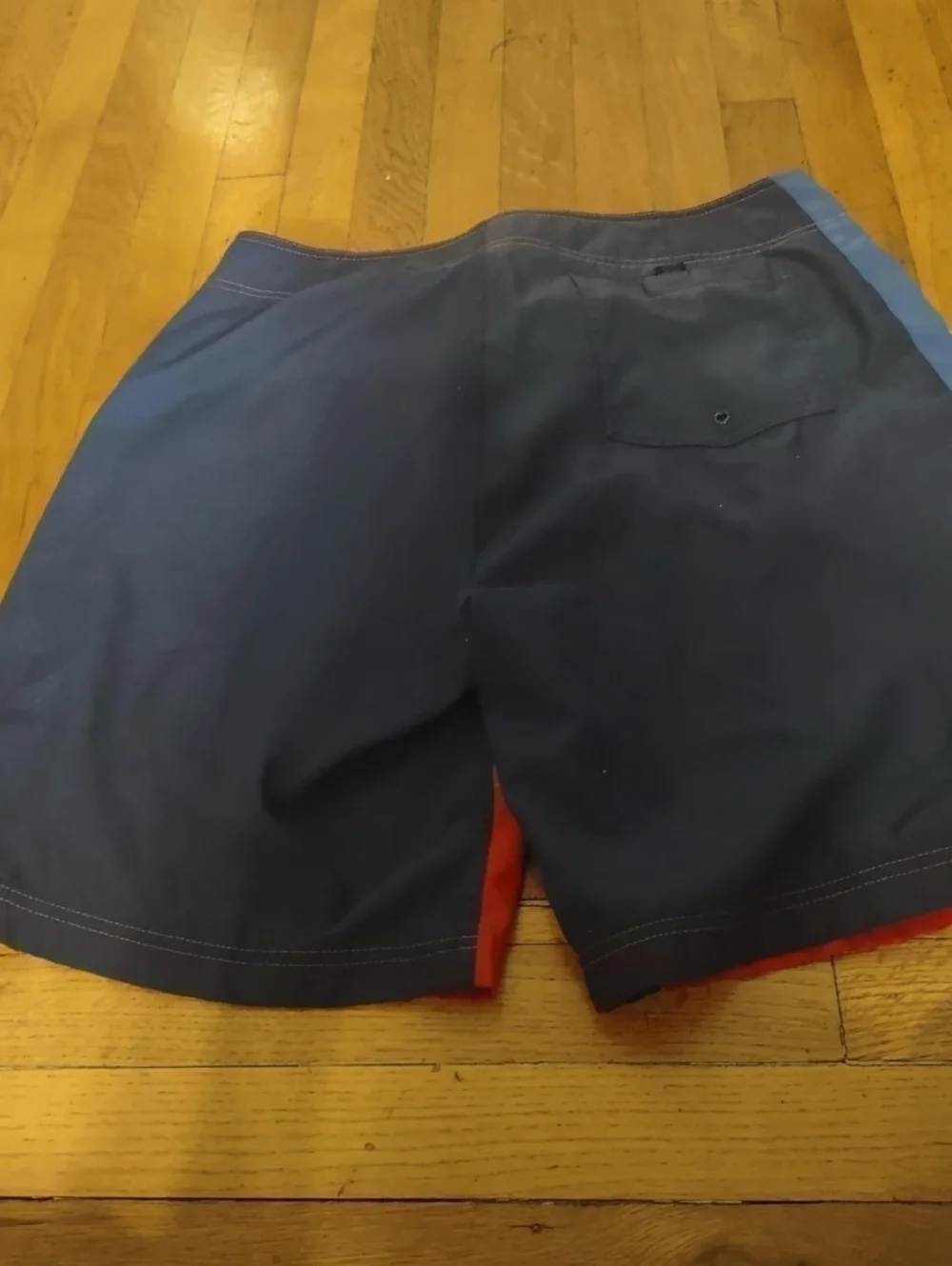 red swim trunks with navy blue back and blue and white stripes from nautica 36W